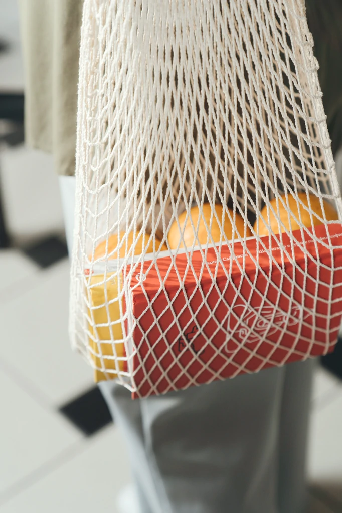 Vista detalle de una cesta con naranjas y un par de libros.