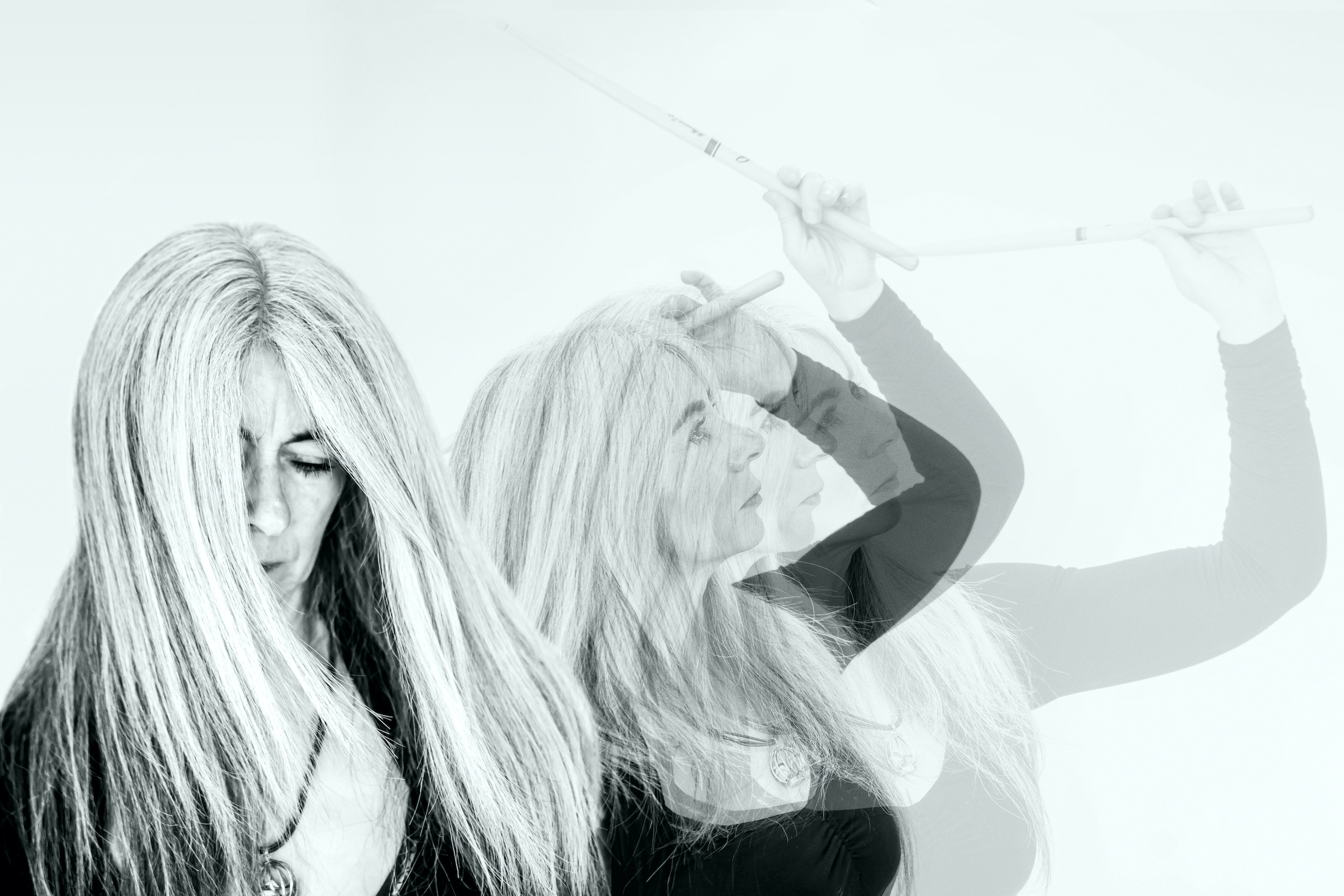 Fotograf&iacute;a en blanco y negro de Evelyn Glennie,&nbsp;percusionista,&nbsp;en pleno movimiento, captada mediante una superposici&oacute;n de gestos. Glennie sostiene baquetas y eleva los brazos, sugiriendo escucha corporal y vibraci&oacute;n.&nbsp;