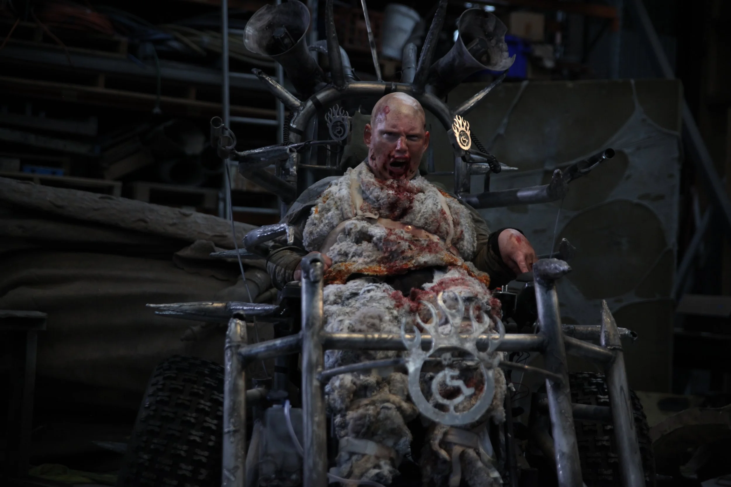 Texto alternativo realizado por www.sampetersen.com.au: "Estoy en mi silla de ruedas apocal&iacute;ptica, equipada con grandes pinchos oxidados y micr&oacute;fonos. Llevo pieles sucias con sangre seca incrustada. Gru&ntilde;o, con sangre alrededor de la boca."